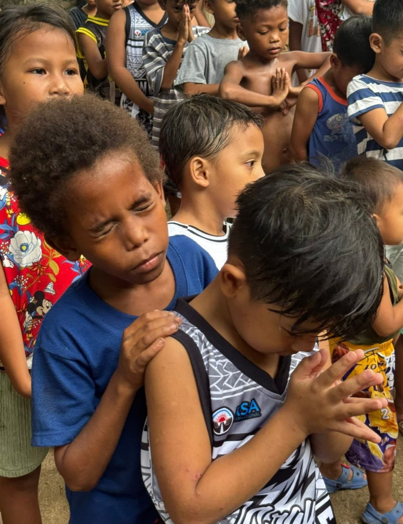 Young children with hands folded in prayer